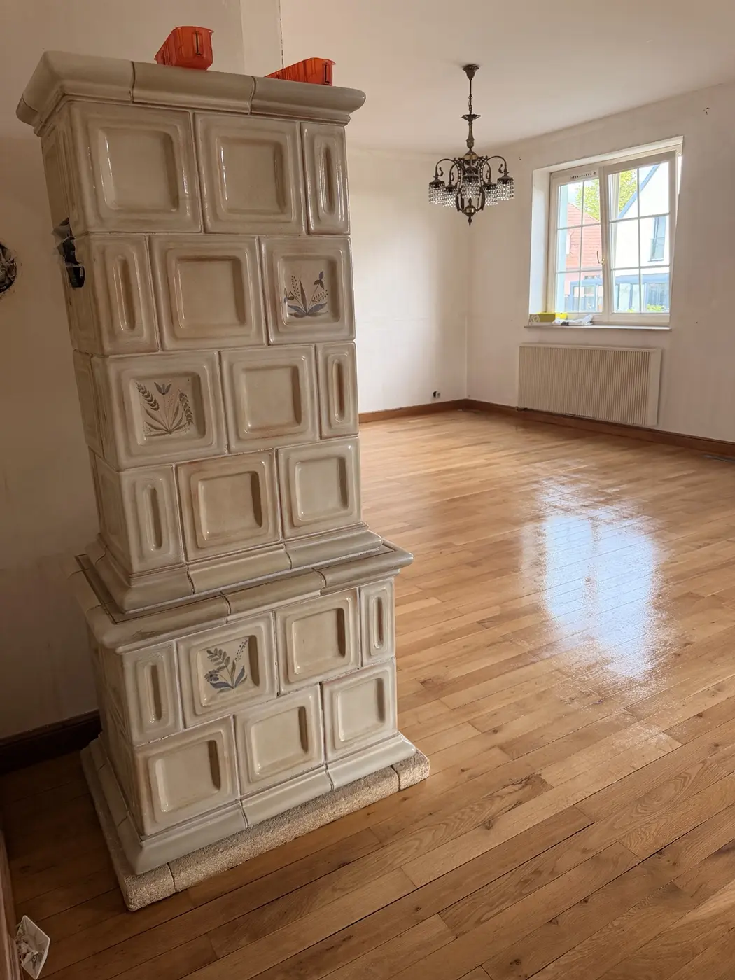 Parquet en bois rénové autour d’un poêle en faïence dans une maison alsacienne