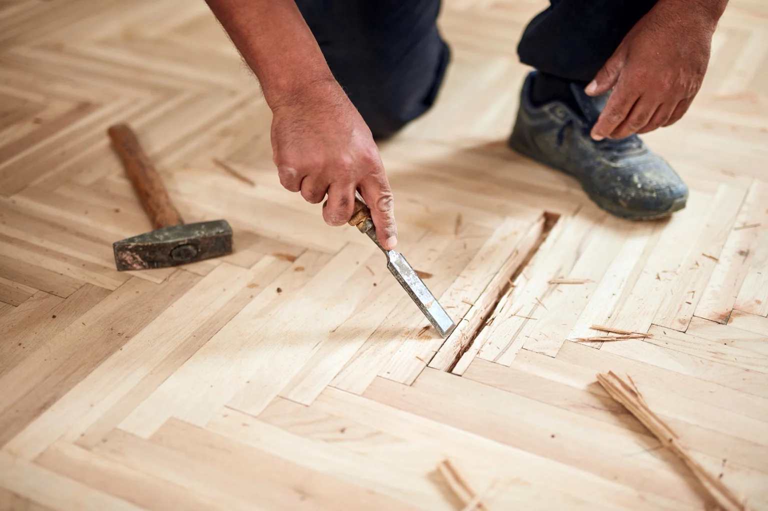 Dépose manuelle au ciseau à bois d’une lame abîmée dans un parquet à bâtons rompus