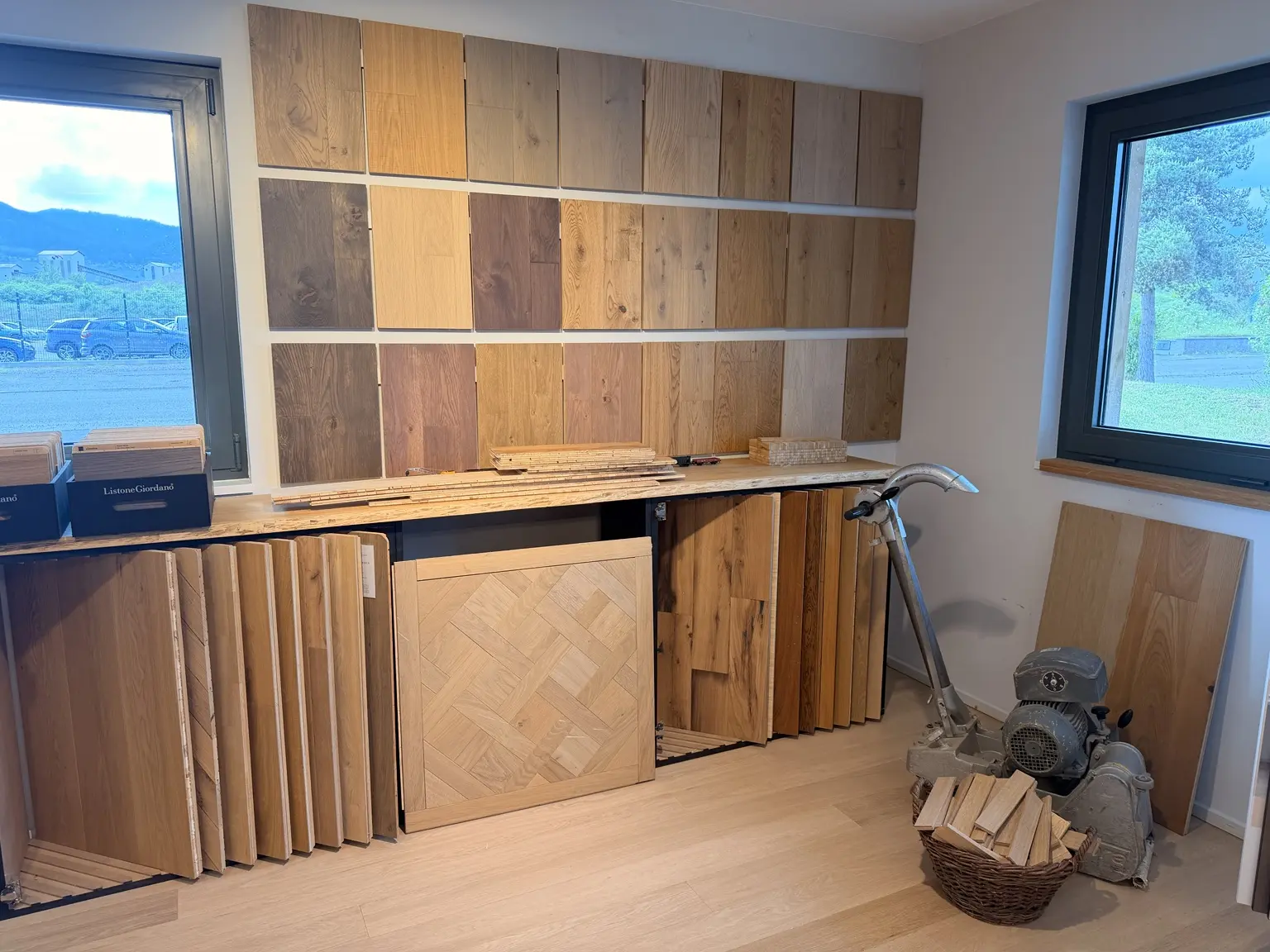 Vue générale du showroom Les Ponceurs Réunis à Herrlisheim-près-Colmar avec mur d’échantillons, panneaux de parquet et ponceuse professionnelle